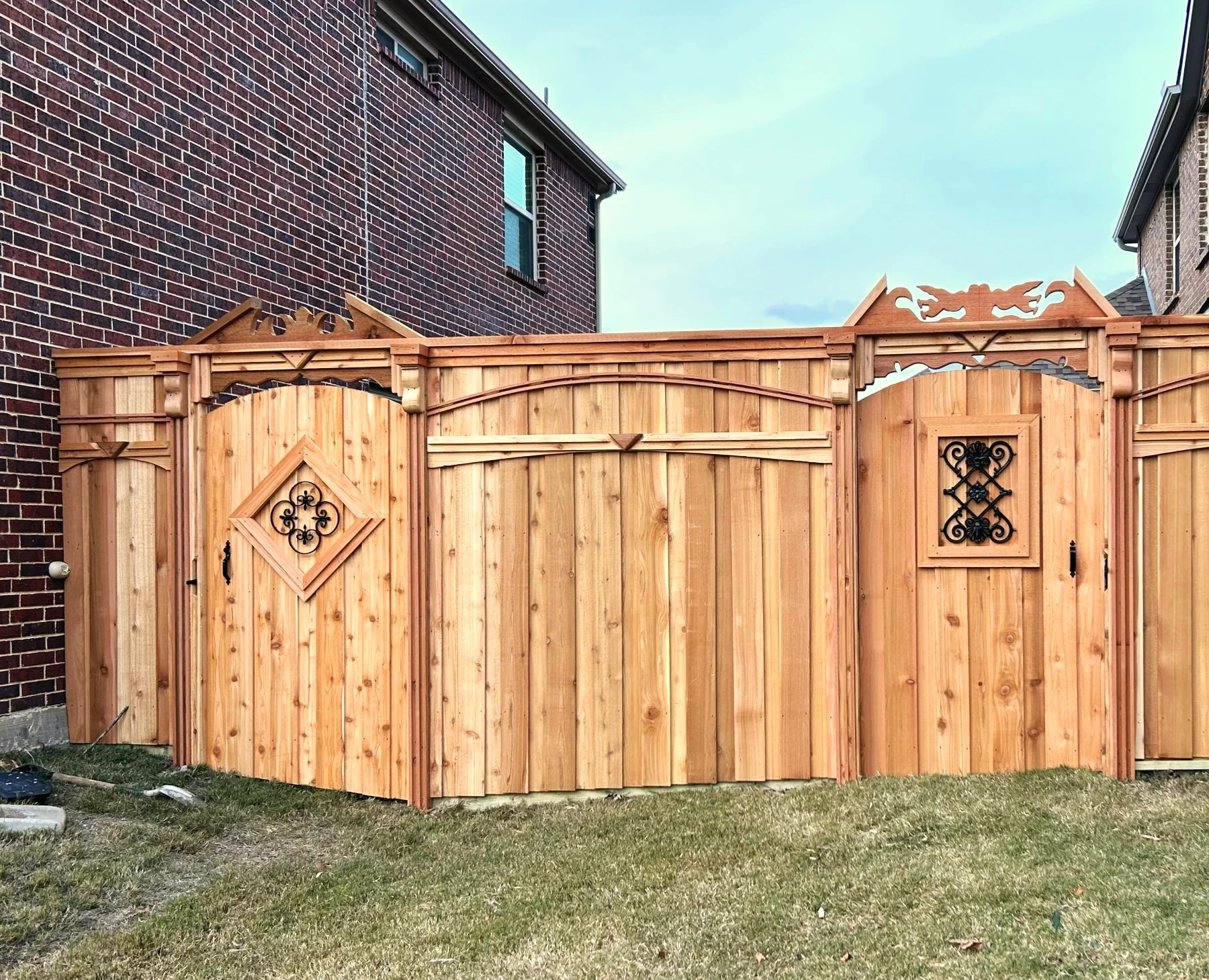 A decorative cedar privacy fence with matching gates, built by Grass DFW